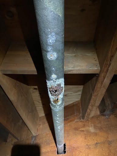 Close-up of scale and mineral buildup on an aging line — a leading cause of slow drains and leaks.